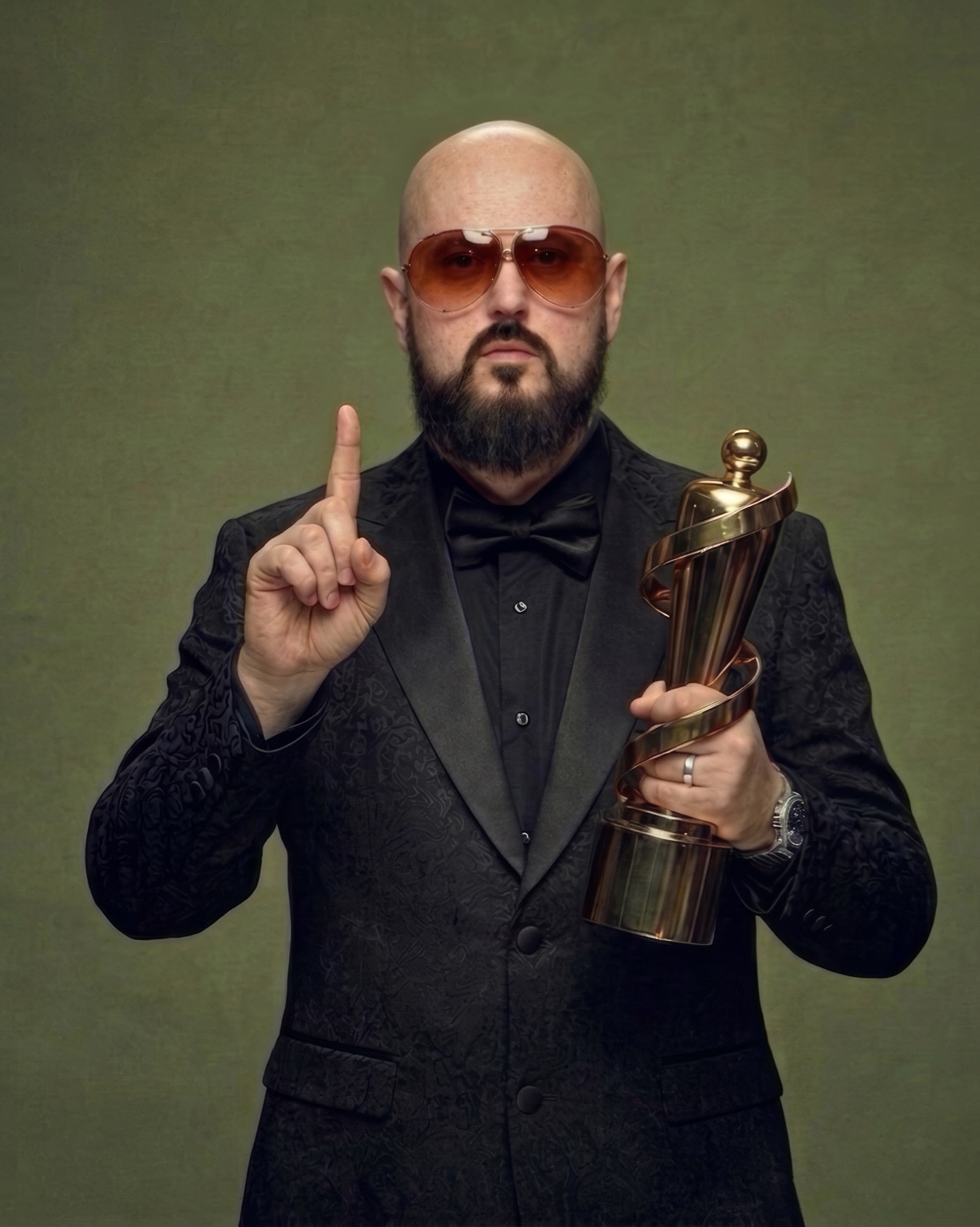 Dub J holding his JUNO trophy against an olive backdrop
